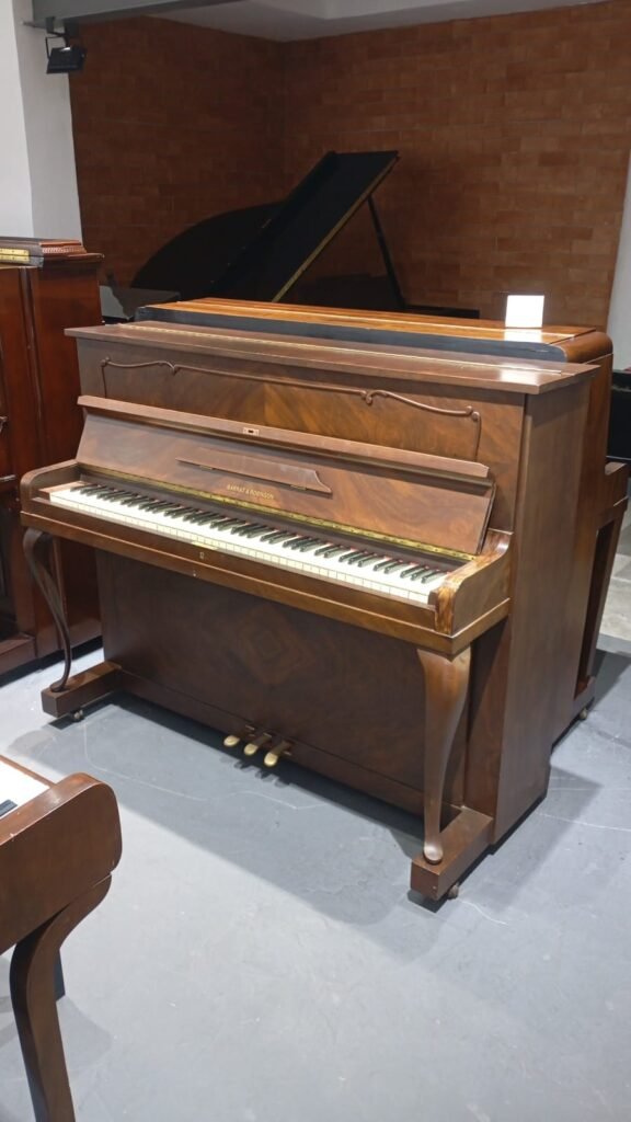 Piano vertical de madeira escura. Ideal para aluguel mensal para estudo musical.