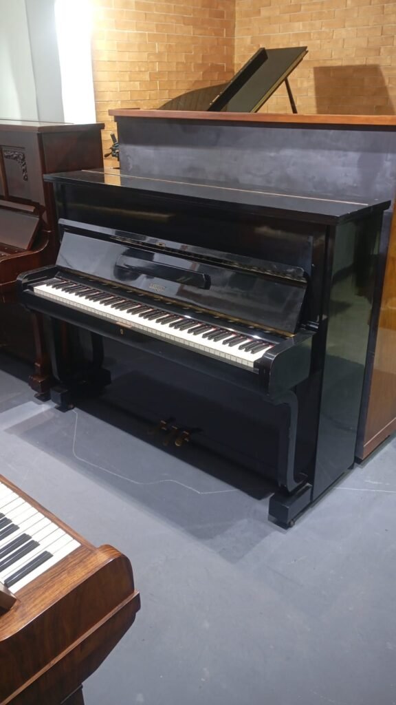 Piano vertical preto para aluguel, ideal para estudo musical.