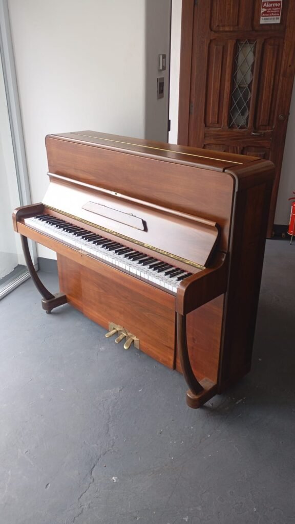 Piano vertical marrom para aluguel mensal, ideal para estudo de música.